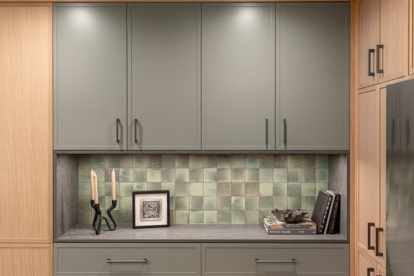 Upper cabinetry with tile backsplash and styled kitchen counter
