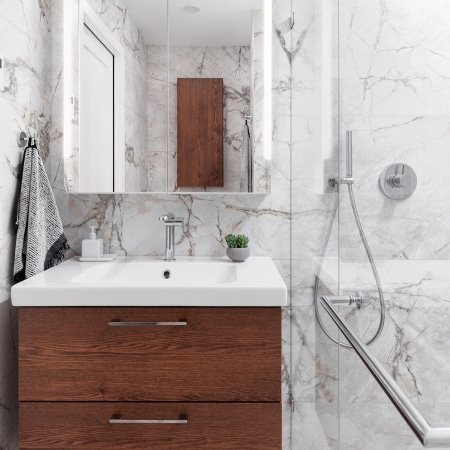 Modern bathroom with custom wood vanity, marble tile, and glass shower completed under Pickard Construction as the general contractor in the Parksville–Qualicum Beach area.