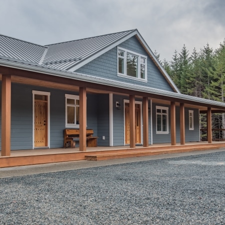 Modern West Coast home exterior with covered porch and natural wood trim completed under Pickard Construction as the general contractor in the Parksville–Qualicum Beach area.